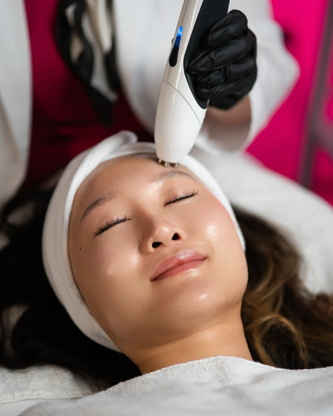 Reclining patient receiving a facial treatment with a handheld device